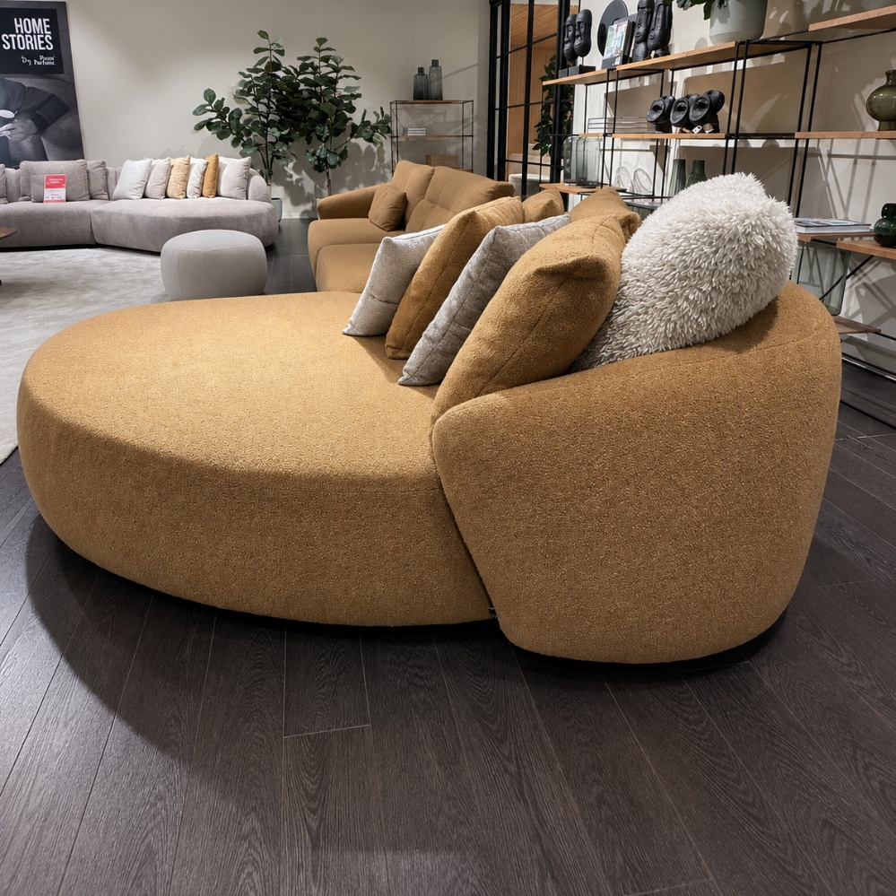 Zijaanzicht van Passe Partout Mostera hoeksalon met organische vormen en chaise longue in mosterdkleurige stof