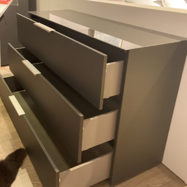 Zijaanzicht van de open Nolte Concept Me 700 commode met hoekgrepen en zwarte poten, beschikbaar bij Verberckmoes Outlet.