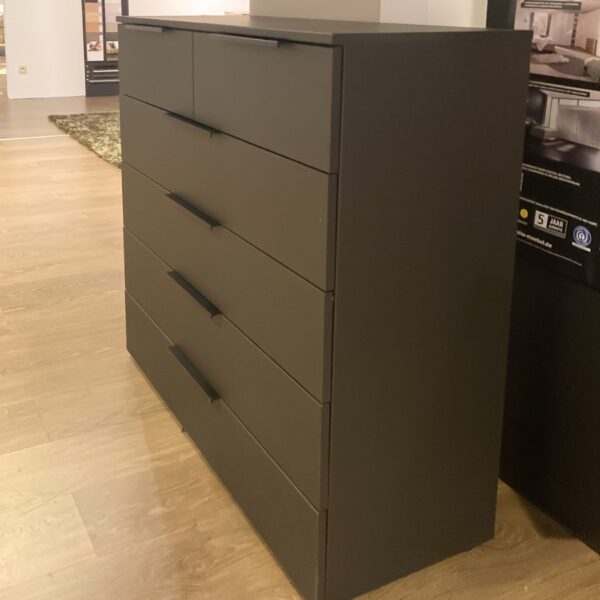 Schuin vooraanzicht van de Nolte CM700 commode met strakke zwarte grepen – Verberckmoes outlet
