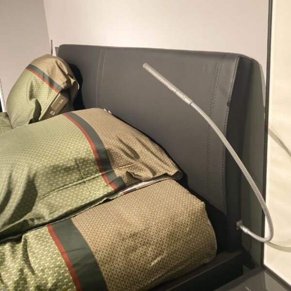 Detail van LED-leeslamp rechts op gestoffeerd hoofdbord van Nolte Concept Me 500 bed