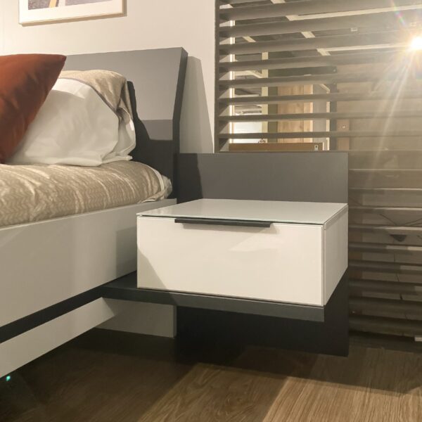 Detail van aflegplankje met lade en glazen bovenblad aan Nolte Concept Me 500 bed