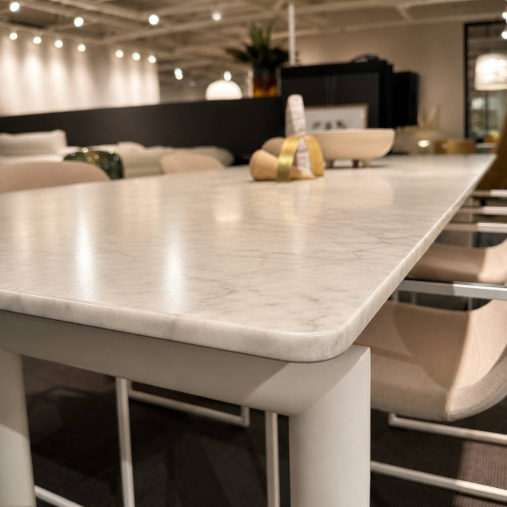 Detail van het Carrara marmeren tafelblad van de Cassina LC6 tafel – afgeronde hoek en natuurlijke marmerstructuur – toonzaalmodel Sint-Gillis-Waas – Verberckmoes