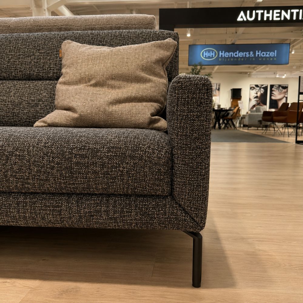 Detail van de armleuning en zwarte metalen poot van de Authentix Loris 3-zit Large elektrisch verstelbare sofa – toonzaalmodel Sint-Gillis-Waas – Verberckmoes
