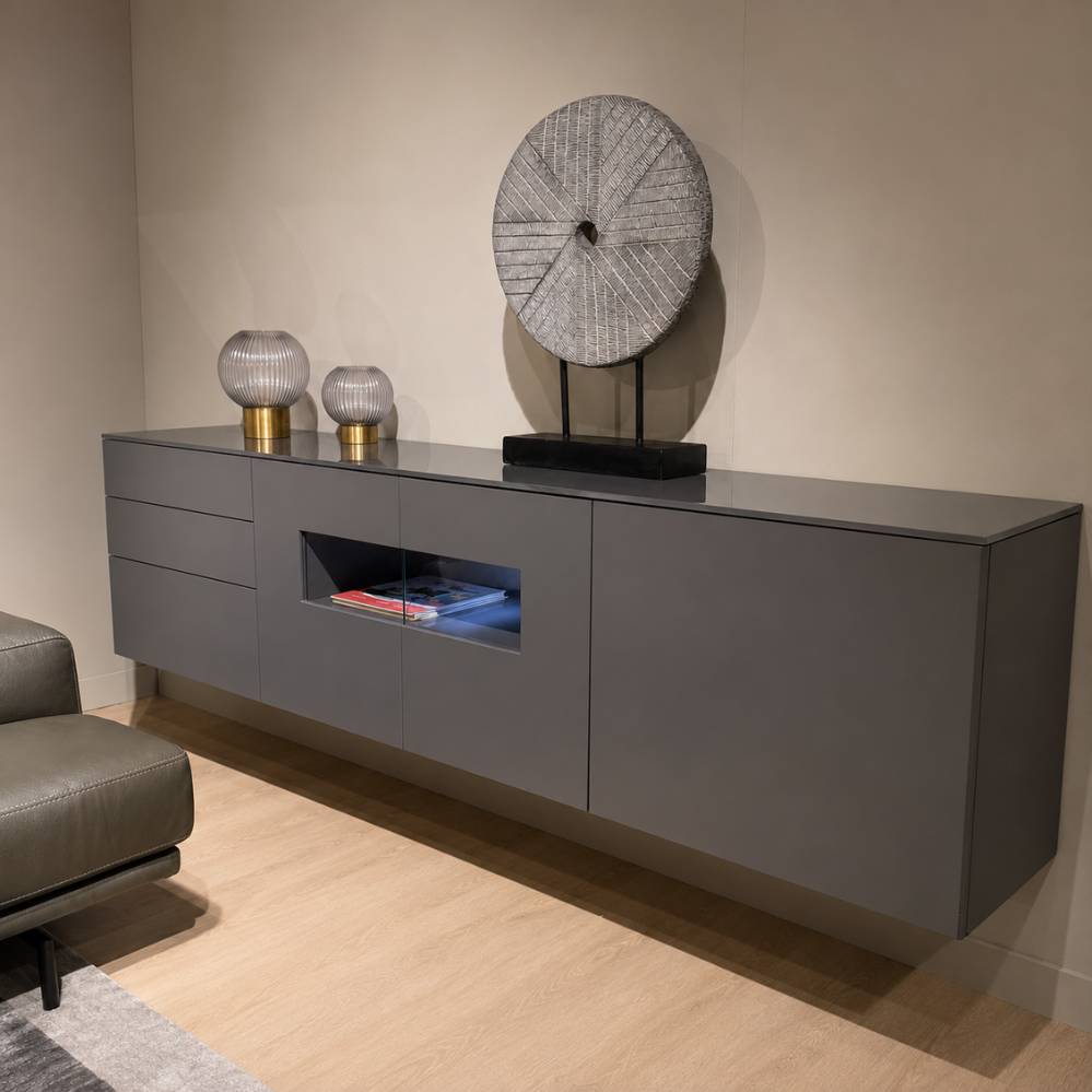 Schuin zijaanzicht van Crest Karat tv-meubel in dark grey met glazen bovenblad en zwevende montage, toonzaalmodel Sint-Gillis-Waas – Verberckmoes