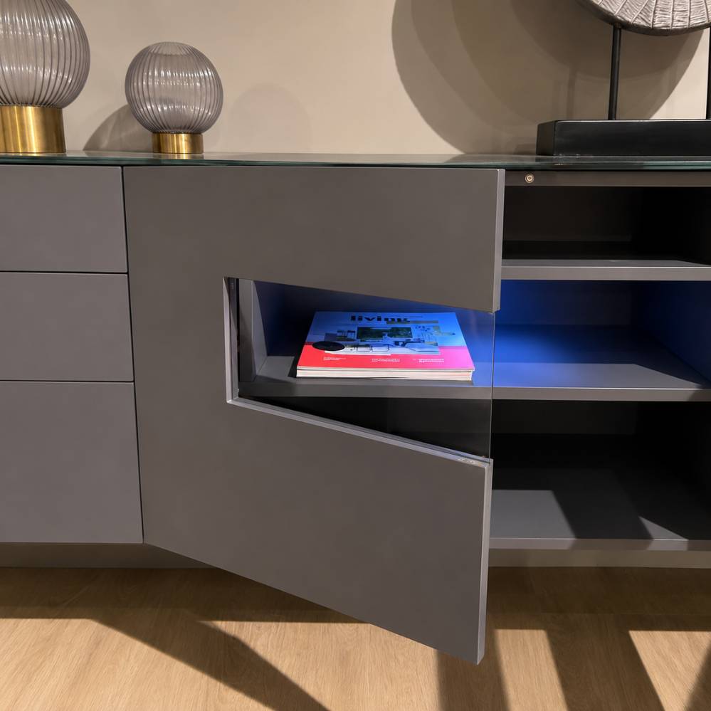 Detail van Crest Karat tv-kast met geopende deuren en geïntegreerd vitrinevak in dark grey, toonzaalmodel Sint-Gillis-Waas – Verberckmoes