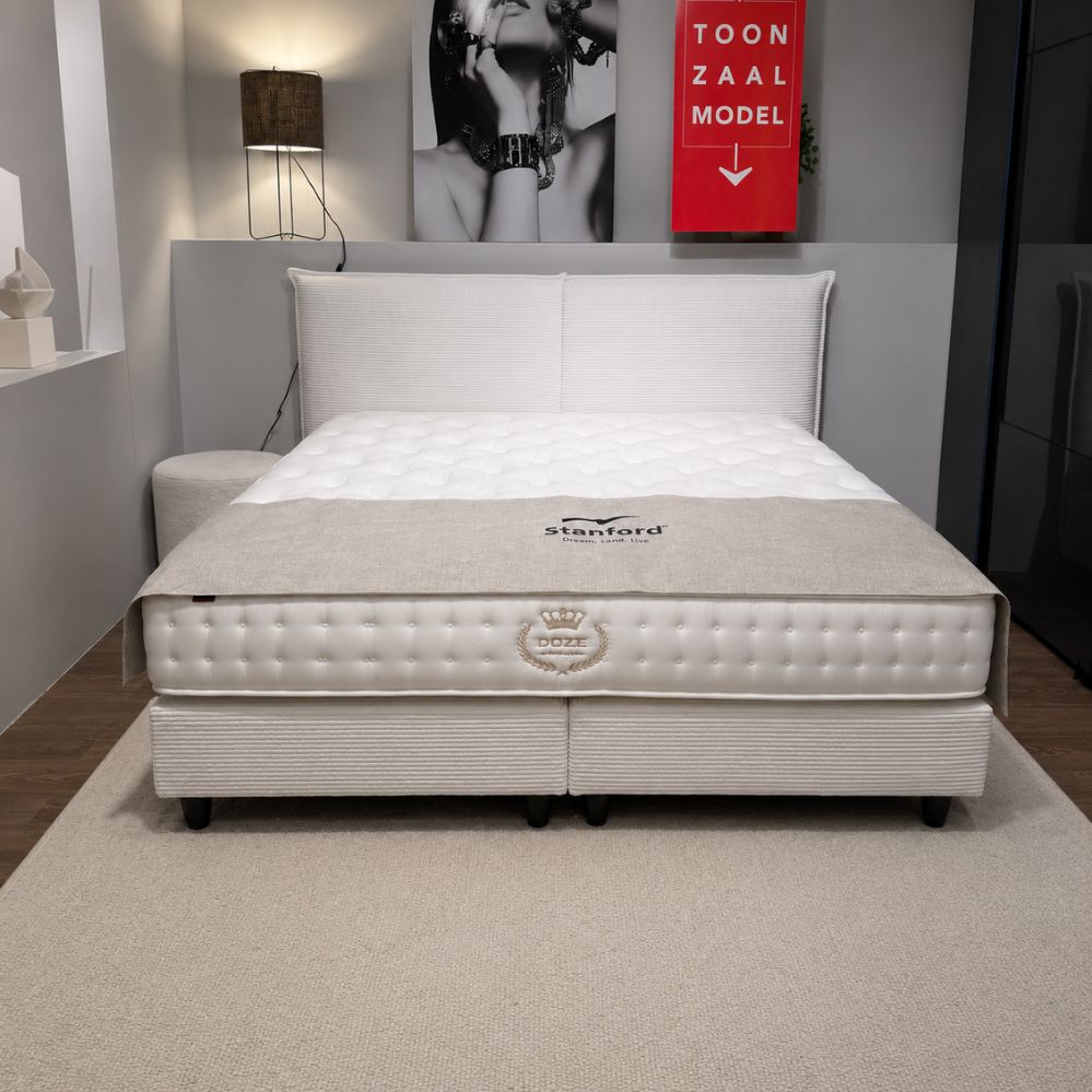 Vooraanzicht van Stanford Freya tweepersoonsboxspring met tweedelig hoofdbord en zwarte poten, toonzaalmodel Sint-Gillis-Waas – Verberckmoes
