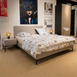 Schuin vooraanzicht van Stanford Parijs boxspring in grijze Cosmos 21545-05 bekleding met twee bijpassende Anna nachtkastjes, toonzaalmodel Sint-Gillis-Waas – Verberckmoes