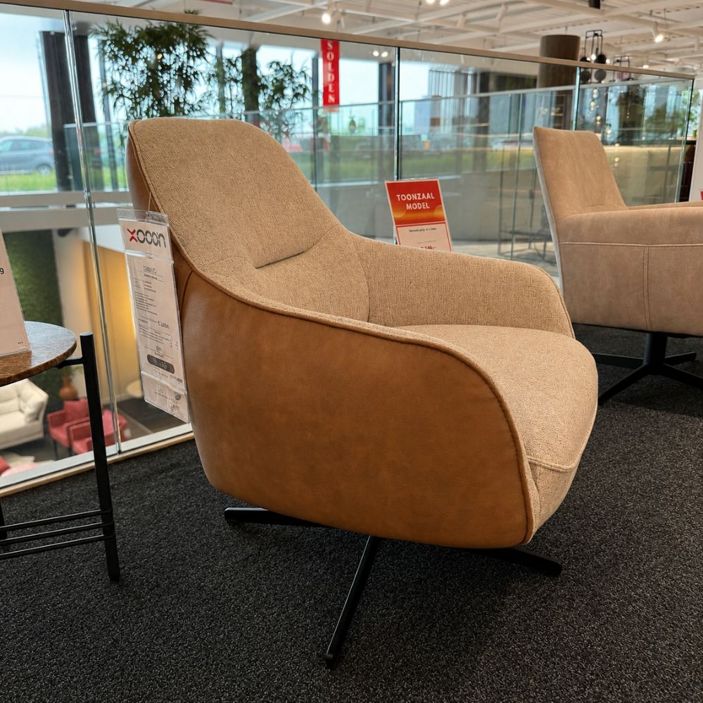 Zijaanzicht van de XOOON Oviedo fauteuil met cognackleurige Pala stof aan de achterzijde – toonzaalmodel Sint-Gillis-Waas