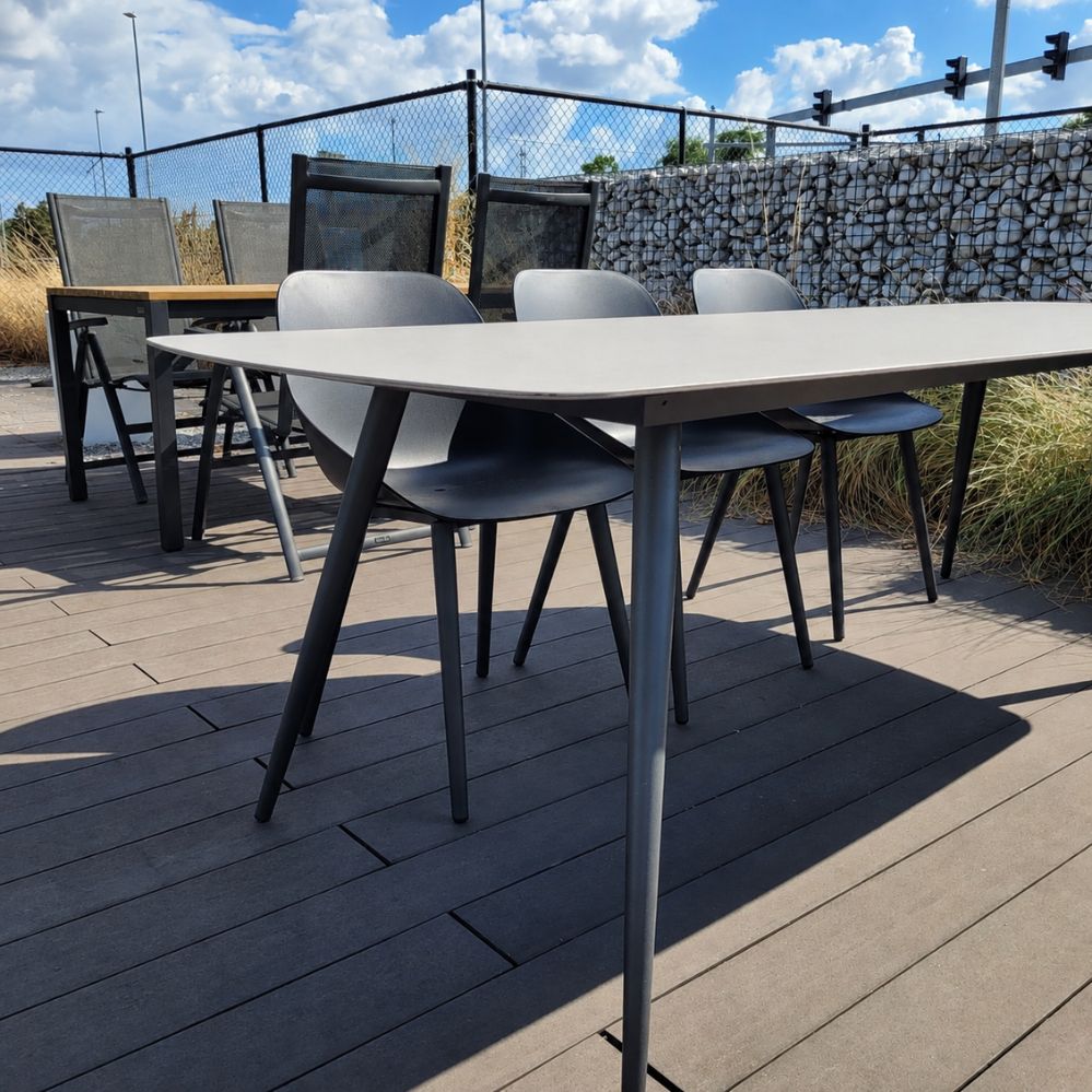Zijaanzicht van de Jati Kebon Amazone tuintafel met charcoal aluminium onderstel en bootvormig keramisch tafelblad als terrasmodel in Temse