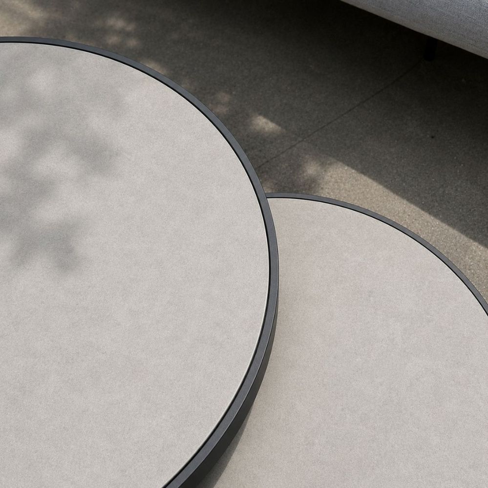Detail van de keramische Cement Grey tafelbladen en charcoal randen van de Jati Kebon Burford salontafels als terrasmodel bij Verberckmoes Tuinmeubelen Temse