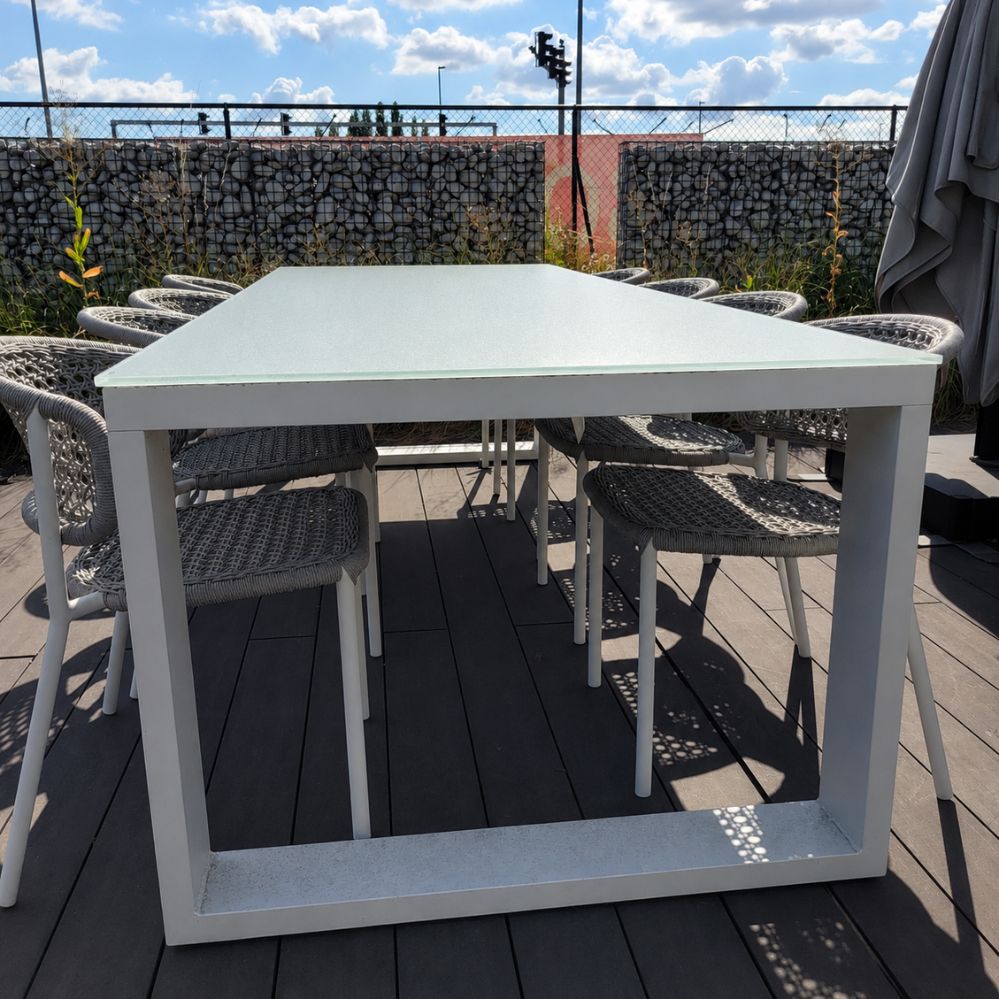 Kopaanzicht van de Jati Kebon Linate tuintafel met wit mat aluminium onderstel en lichtgrijs glazen tafelblad als terrasmodel in Temse