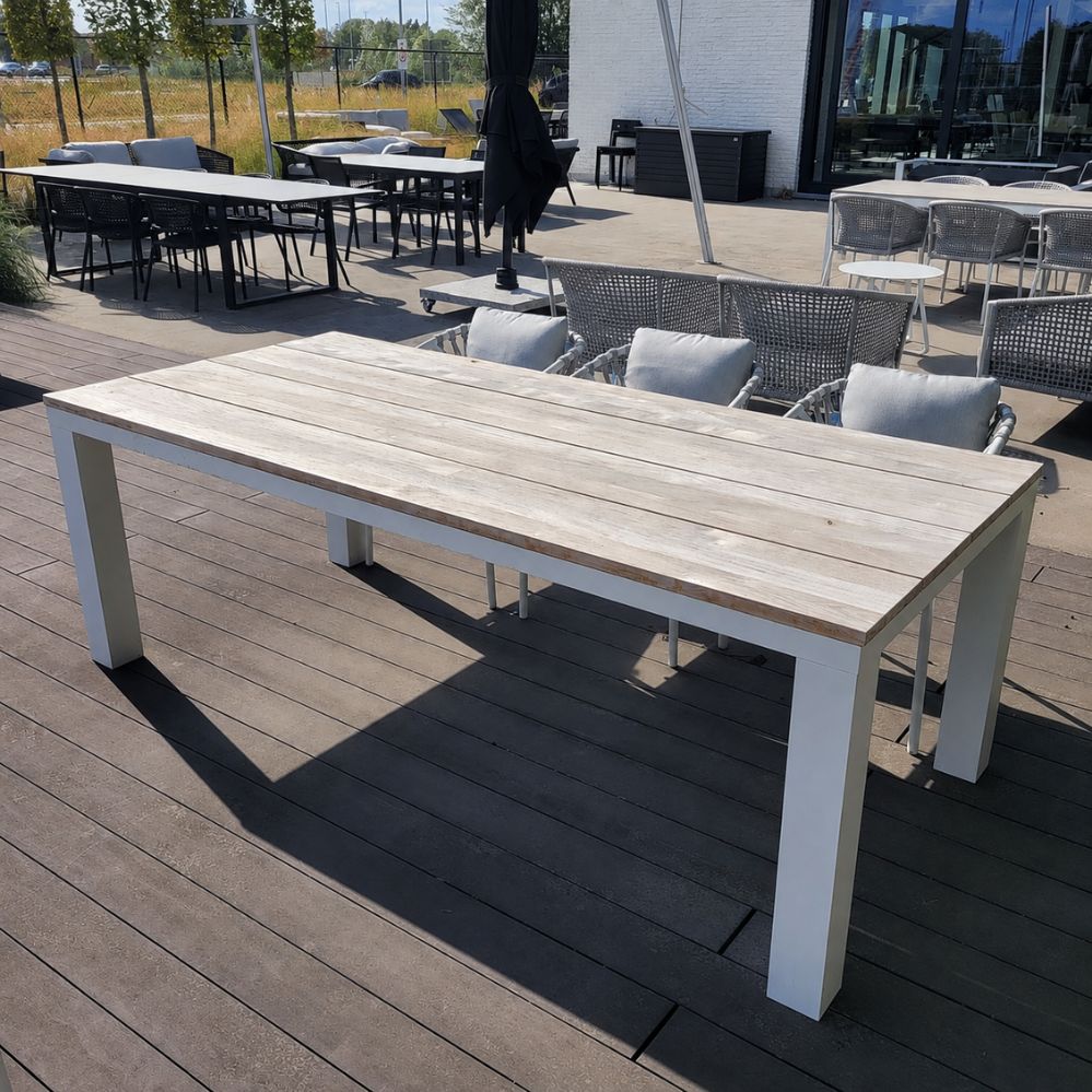 Zijaanzicht van de Jati Kebon Square tuintafel 220 × 100 cm met wit aluminium frame en teakhouten tafelblad als terrasmodel in Temse
