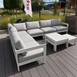 Schuin zijaanzicht van de Jati Kebon Vigo hoekloungeset links met wit aluminium frame en kussens in Sunbrella Natté Grey Chiné als terrasmodel in Temse