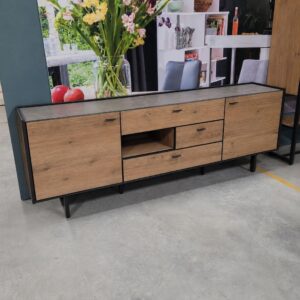 XOOON Fresno dressoir in burned eikenfineer met HPL bovenblad in betonlook en zwart metalen onderstel als toonzaalmodel bij Meubelen Verberckmoes Sint-Gillis-Waas